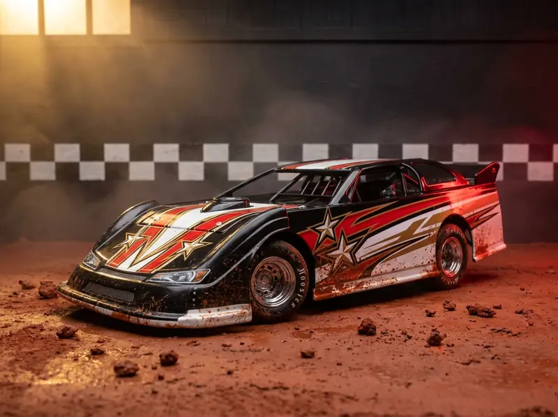 Concept illustration: a black, red and gold dirt late model diecast on packed red clay, mud splattered along its sides.
